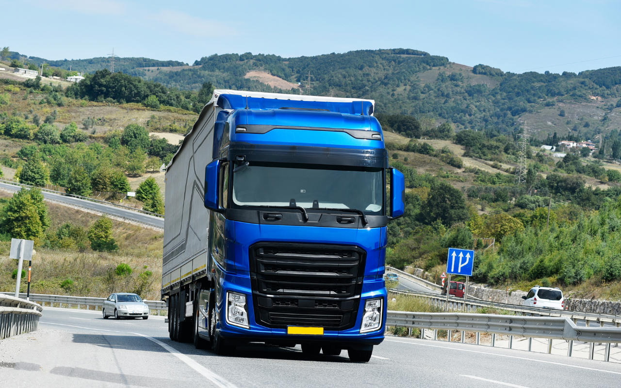 Driver standing beside a semi-truck ready for delivery services